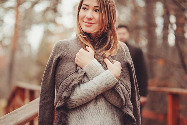 Woman in Cozy Warm Cardigan (Photo: Maria Evseyeva/ Shutterstock) Woman in cozy warm cardigan walking outdoor in autumn forest
