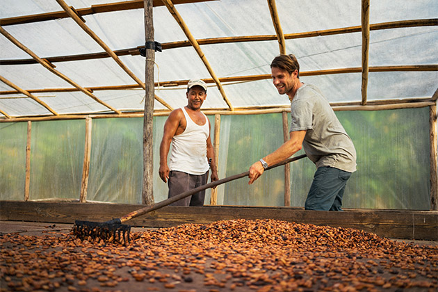 A cacao nursery in the Dominican Republic (Photo: Fathom) Fathom passenger raking cacao beans at a nusery in the Dominican Republic