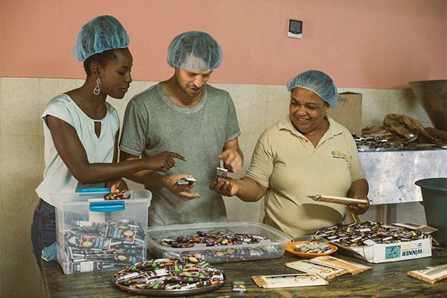Fathom passengers working in the chocolate factory (Photo: Fathom) Fathom passengers and local woman working in the chocolate factory