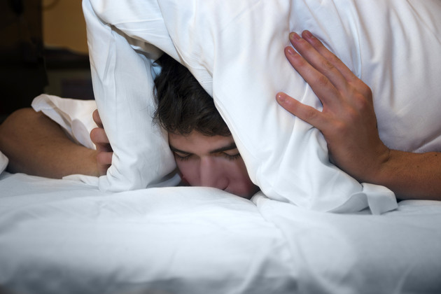 Check the deck plans to make sure you're not too close to kids' clubs or late night hot spots if you like to get to bed early. (photo: Stefano Cavoretto/Shutterstock) man trying to sleep