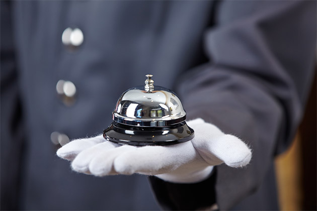 Butler service on a cruise (Photo: Robert Kneschke/Shutterstock) Butler holding a bell