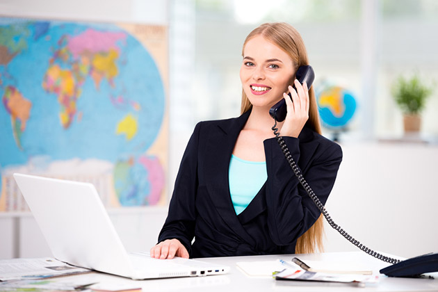 Booking the Tour (Photo: Dima Sidelnikov/ Shutterstock) Photo of female travel agent. Travel agency office interior with big world map