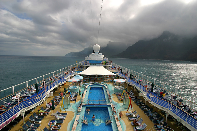 Cruise ship near Kauai (Photo: Bryan Busovicki/Shutterstock.com) Wide angle view of cruise ship deck sailing along the Na Pali Coast on the island of Kauai in Hawaii