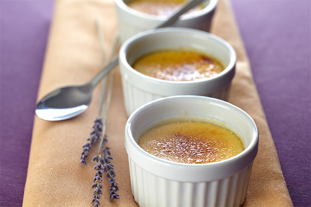Lavender creme brulee (Photo: belushi/Shutterstock.com) Creme Brulee in three little baking molds on a beige napkin placed on a violet tablecloth. Decorated with lavender blossoms. violet lavender blooms. Shallow depth of field
