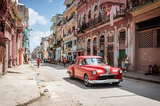 Classic American car in downtown Havana (Photo: Atomazul/Shutterstock.com) Classic red American car being used as a taxi in downtown Havana, Cuba, with locals