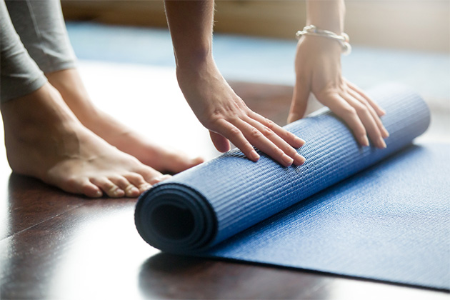 Thai chi wellness excursion (Photo: fizkes/Shutterstock.com) Close-up of a woman unfolding blue fitness mat