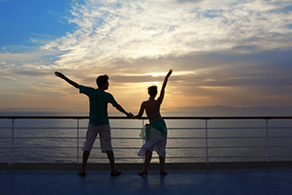 Couple standing on a cruise ship deck - photo compliments of Pavel L Photo and Video/Shutterstock happy cruising