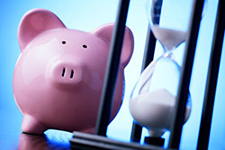 Save money by waiting - photo courtesy of sergign/Shutterstock Hourglass and piggybank