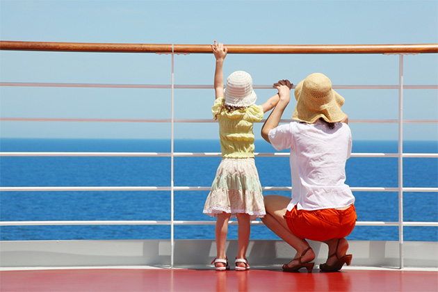 Single parent cruising (Photo: Pavel L Photo and Video/Shutterstock.com) behind mother and her daughter standing on deck of yacht and they look far aboard