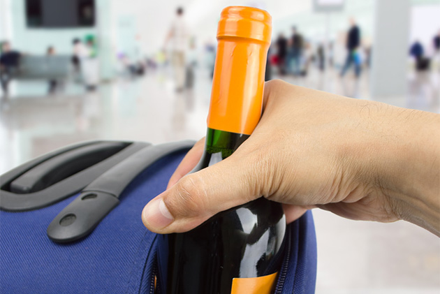 Worst cruise packing mistake #16 (Photo: cunaplus/Shutterstock.com) Wine bottle in suitcase